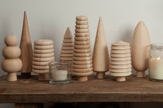 wooden toys and candles sit on a table next to a candle holder, which is made from wood