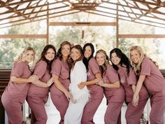 a group of women standing next to each other in front of a wooden ceilinged room