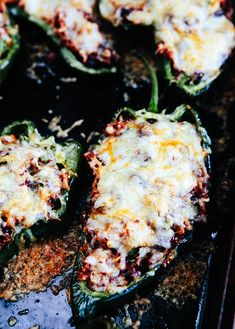 several stuffed peppers on a baking sheet with cheese