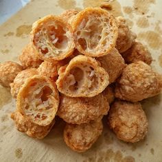 a pile of fried food sitting on top of a wooden cutting board