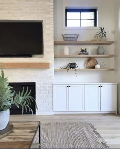 a living room with white brick fireplace and entertainment center