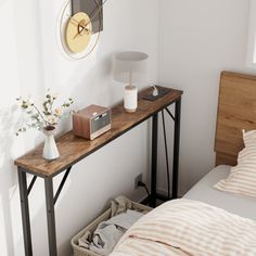 a bed room with a neatly made bed and a wooden shelf on the side table