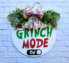 a sign that says grin mode on the side of a building with wreaths and bows