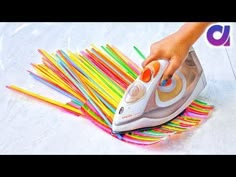 someone is ironing colored straws with an iron