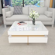 a living room with a couch, coffee table and large window looking out on the city