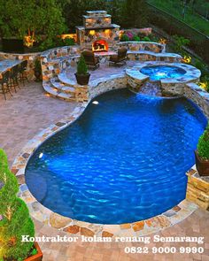 an outdoor swimming pool surrounded by stone steps and patio furniture with fire pit in the middle