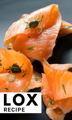 four pieces of smoked salmon on a black plate with the words lox recipe below it