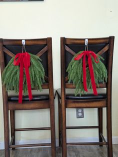 two chairs with christmas wreaths tied to them