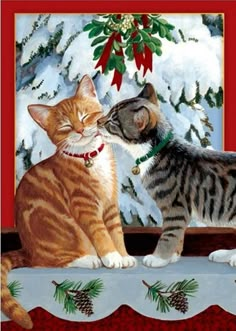 two cats sitting next to each other in front of a christmas tree