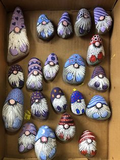 a box filled with lots of painted rocks covered in gnomes'heads and beards