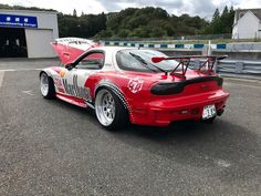 a red and white car parked on top of a parking lot