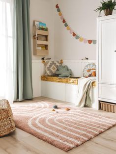 a child's bedroom with white walls and wooden flooring is decorated in pastel colors