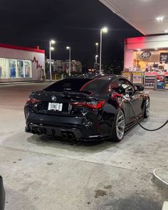 a black sports car parked at a gas station