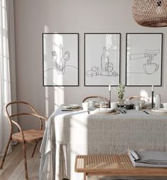 a dining room table with three pictures on the wall