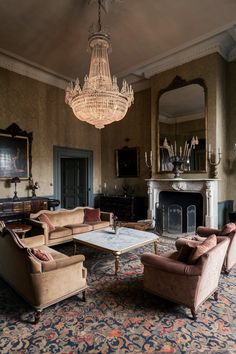 a living room with couches, chairs and a chandelier hanging from the ceiling