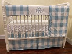 a blue and white plaid crib bedding set with the monogrammed initials on it