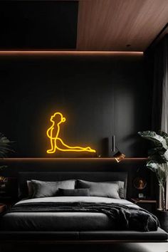 a bed with a neon sign on the wall above it and a plant next to it