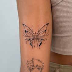 a woman's arm with a butterfly tattoo on the left side of her arm