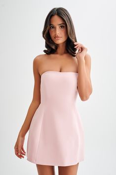 We recommend sizing up in this style. When the dress IS the party.The NEEKA is a strapless mini dress with a low sweetheart neckline and flared skirt. Three beautiful contrast bows are lined up at the centre back, adding visual texture and a touch of feminine charm. The back itself is low with a deep V-shaped neckline. Airy tulle underlayers add playful volume while the tucked waist accentuates a slender, curvy silhouette. Flatteringly feminine, NEEKA is the perfect blend of childish whimsy and Light Pink Dress Short, Strapless Pink Dress, Mini Pink Dress, Mink Dress, Triangle Dress, Curvy Silhouette, Semi Dresses, Pink Dress Short, Light Pink Shorts