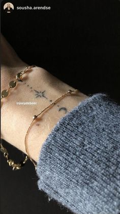 a person's arm with tattoos on it and bracelets attached to the wrist