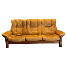 a brown leather couch sitting on top of a wooden frame