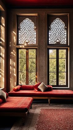 a living room filled with red couches and two large windows next to each other