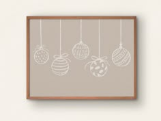 an image of christmas ornaments hanging from strings on the wall in front of a white wall