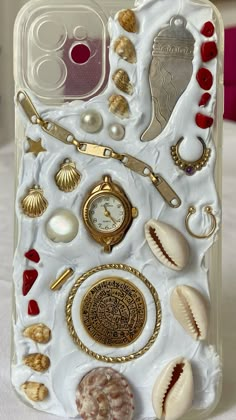 an iphone case with shells, seashells and other items on it's side