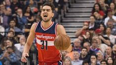 a man holding a basketball in his right hand and looking at the camera with an excited look on his face