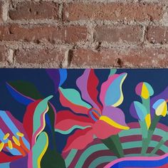 a colorful painting on a brick wall