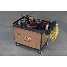 a tool box with tools in it sitting on top of a floor next to a wire