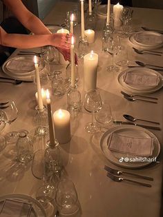 a long table is set with candles and place settings