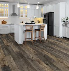 a large kitchen with white cabinets and wood flooring, along with two bar stools