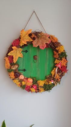 a green door is decorated with autumn leaves and other things to decorate on the wall