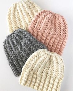 three knitted hats are shown on a white surface