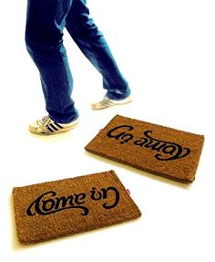 two doormats with the words come to germany and someone standing next to them