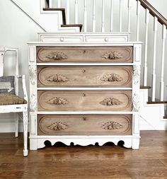 a white dresser sitting next to a stair case