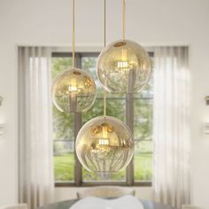 three glass balls hanging from the ceiling above a bed