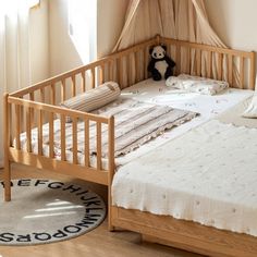 a baby crib in the corner of a room with a teddy bear on it