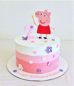 a peppa pig birthday cake with pink frosting and flowers on the bottom layer