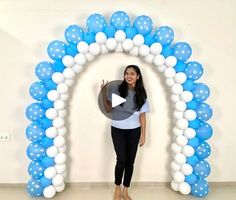 a woman standing in front of a blue and white arch