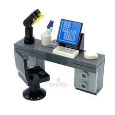 a computer desk with a laptop and microscope on it, in front of a white background