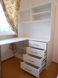 a white desk with drawers underneath a window