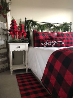 a bedroom decorated for christmas with red and black plaid bedding