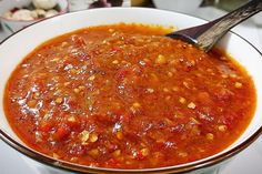 a white bowl filled with lots of red sauce