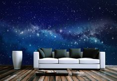 a couch sitting on top of a wooden floor under a night sky filled with stars