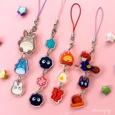 several key chains with cartoon characters on them and star charms around them, all in different colors