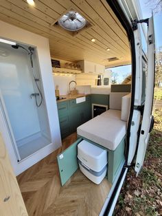 the interior of a camper van with its door open to reveal a kitchen area