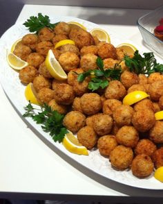 a platter filled with tater tots and lemon wedges