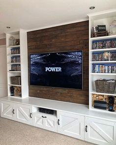 an entertainment center with bookshelves and a flat screen tv mounted on the wall